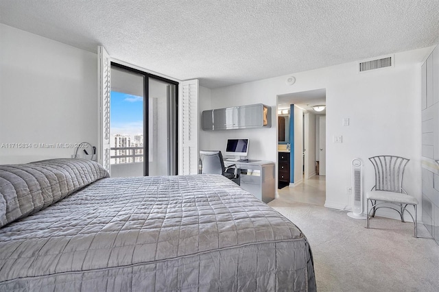 carpeted bedroom with a textured ceiling and access to outside