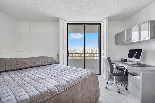 bedroom featuring access to exterior, light carpet, and a textured ceiling