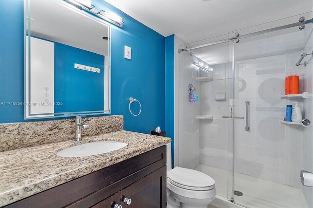 bathroom with toilet, vanity, and walk in shower