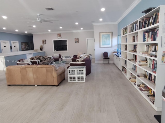 living room with crown molding, ceiling fan, and light hardwood / wood-style floors