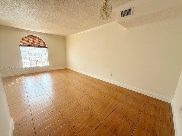 spare room featuring a textured ceiling and ornamental molding