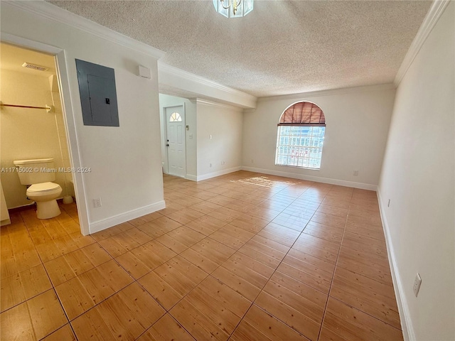 spare room with electric panel, a textured ceiling, and ornamental molding