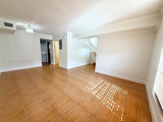 unfurnished room featuring a textured ceiling, electric panel, and crown molding