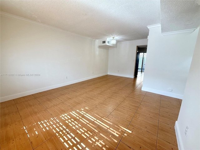 spare room featuring crown molding and a textured ceiling