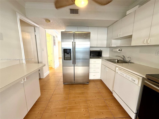 kitchen with white cabinets, appliances with stainless steel finishes, ornamental molding, and sink