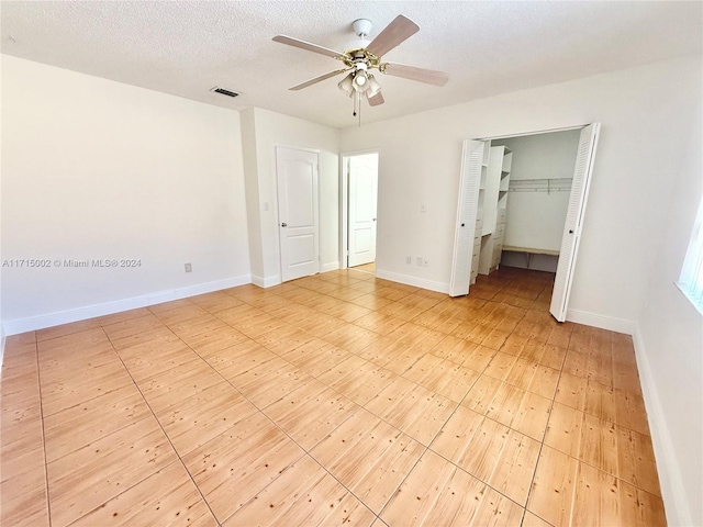 unfurnished bedroom with ceiling fan, a closet, and a textured ceiling