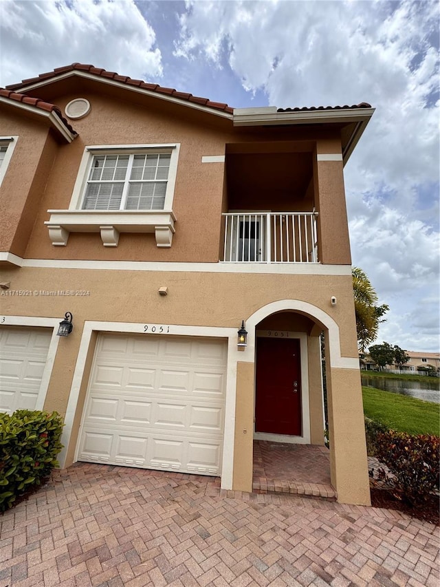 view of front of property with a garage and a balcony