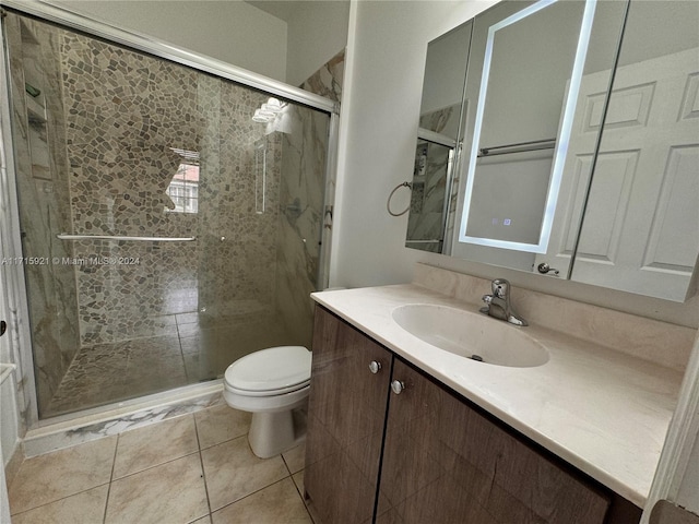 bathroom featuring tile patterned floors, vanity, toilet, and an enclosed shower