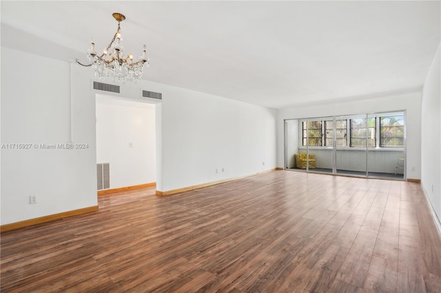 empty room with a chandelier and hardwood / wood-style flooring