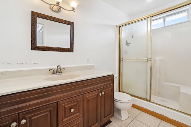 bathroom with toilet, vanity, tile patterned floors, and an enclosed shower