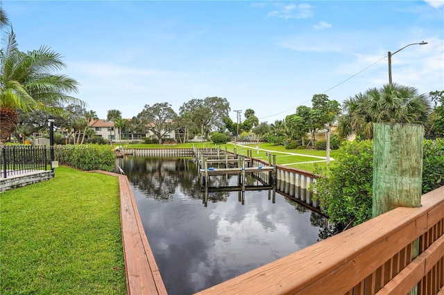 view of dock with a yard and a water view