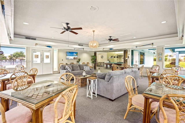 living room featuring carpet flooring, french doors, a textured ceiling, a tray ceiling, and ceiling fan