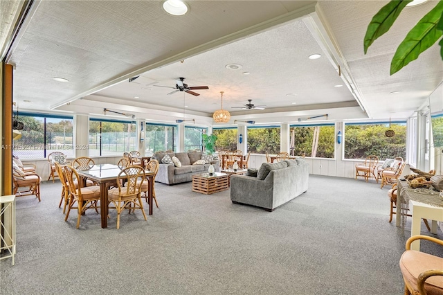 sunroom / solarium with a tray ceiling and ceiling fan