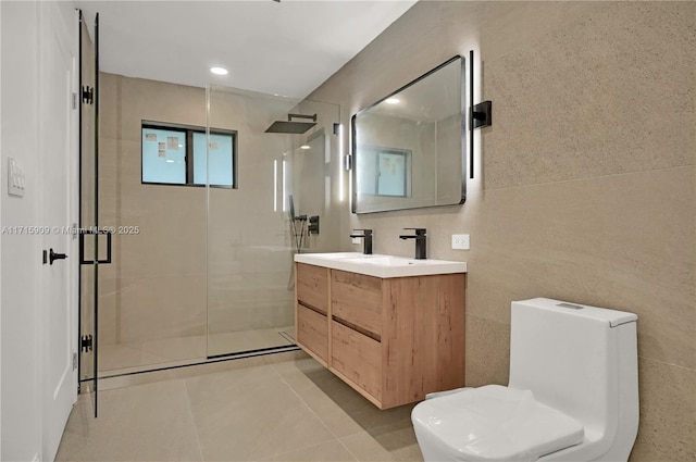 bathroom with walk in shower, tile patterned floors, toilet, vanity, and tile walls