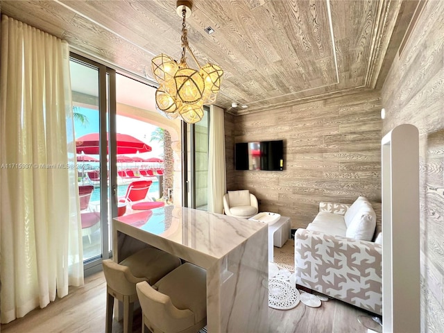 dining room with wooden ceiling, wooden walls, a notable chandelier, and wood finished floors