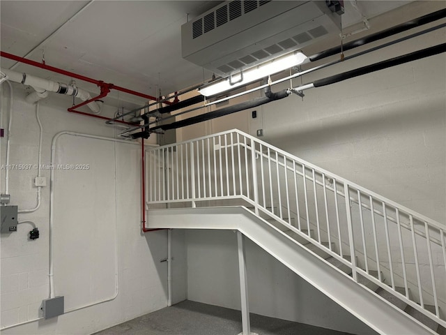staircase featuring concrete block wall