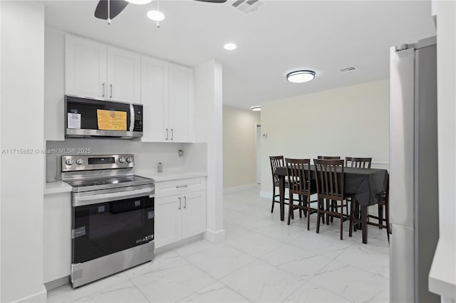 kitchen with white cabinetry, stainless steel appliances, and ceiling fan