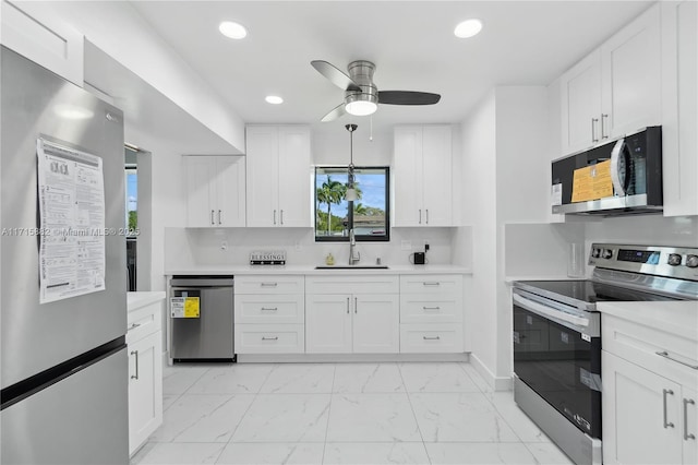 kitchen with appliances with stainless steel finishes, sink, white cabinets, decorative backsplash, and ceiling fan