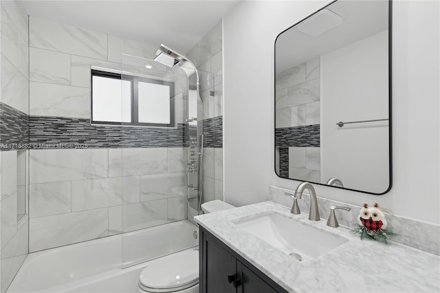 full bathroom featuring tiled shower / bath combo, vanity, and toilet