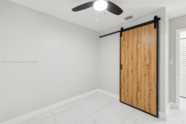 unfurnished bedroom with ceiling fan and a barn door