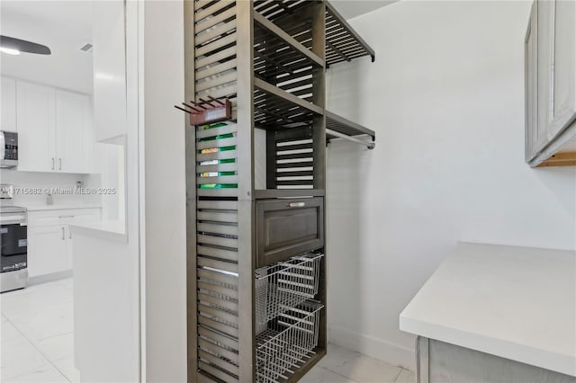 interior space featuring white cabinetry and appliances with stainless steel finishes