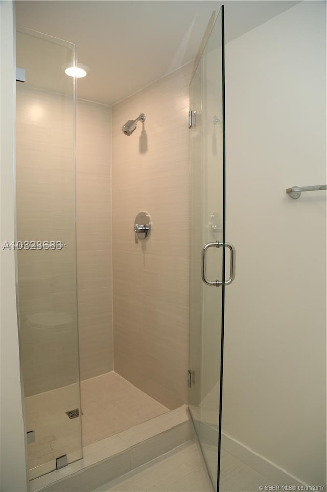 bathroom featuring tile patterned flooring and a shower with shower door