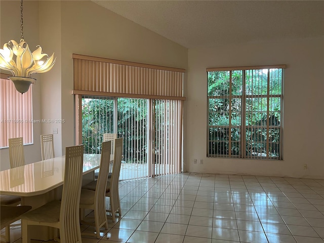 unfurnished dining area with light tile patterned flooring, a healthy amount of sunlight, high vaulted ceiling, and an inviting chandelier