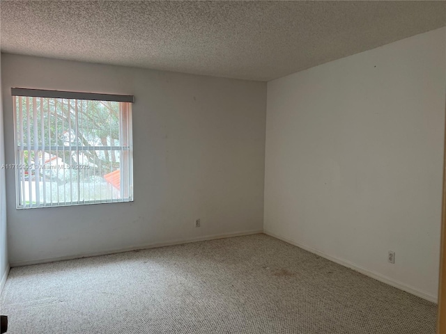 carpeted empty room featuring a textured ceiling