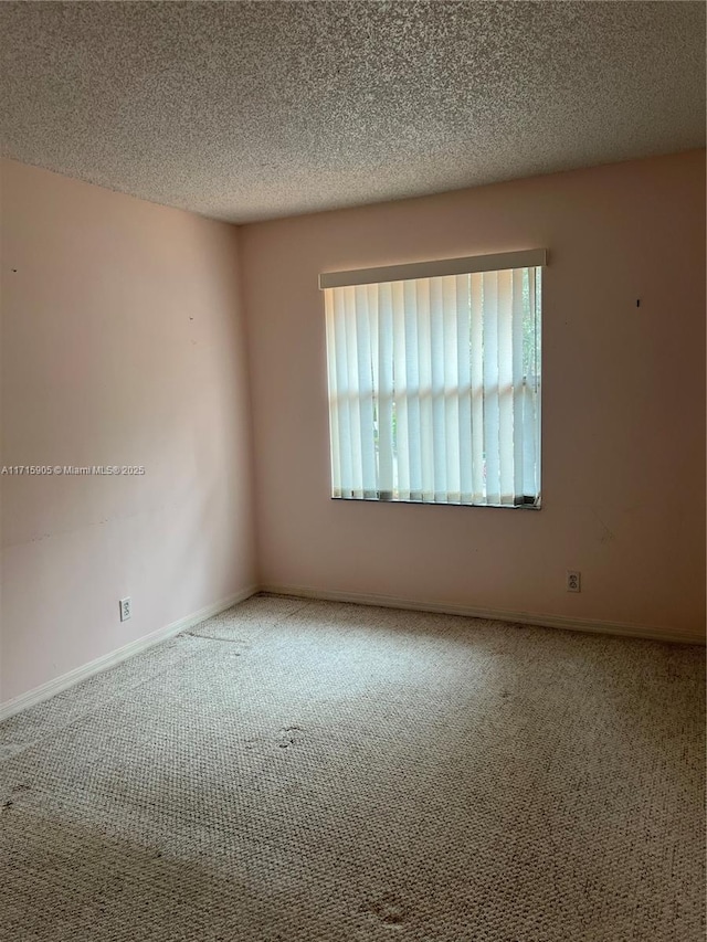 spare room with a textured ceiling and carpet floors