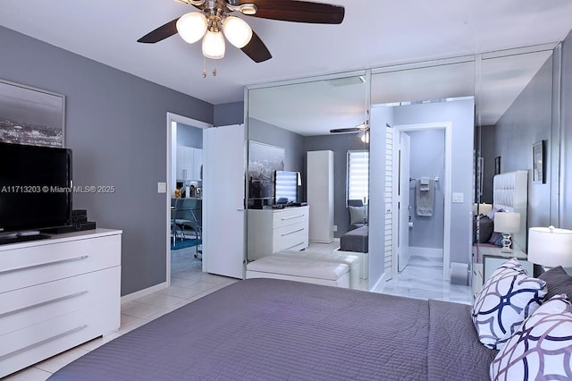 bedroom with baseboards, a ceiling fan, and ensuite bathroom