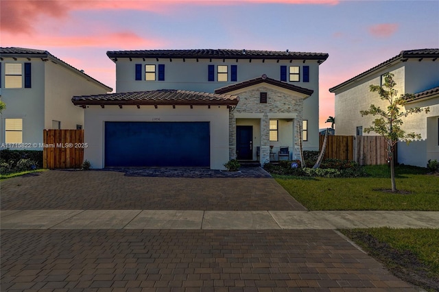 mediterranean / spanish-style house featuring a garage and a yard