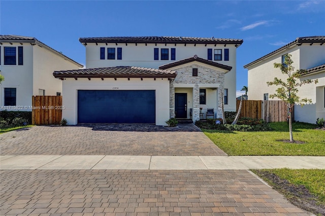 mediterranean / spanish-style home featuring a garage and a front lawn