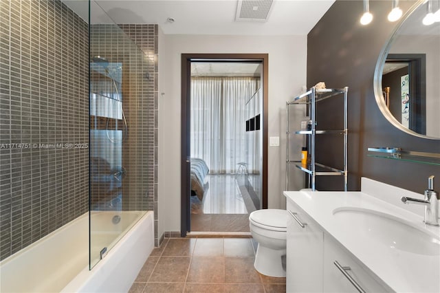 full bathroom featuring tile patterned floors, vanity, enclosed tub / shower combo, and toilet