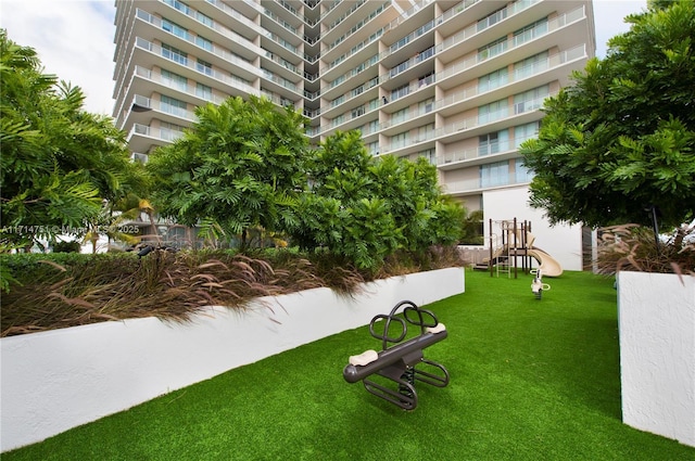 view of home's community with a playground and a yard