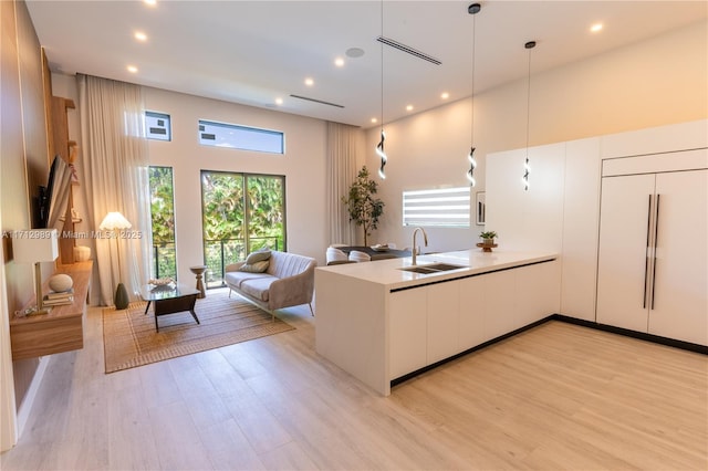 kitchen featuring a wealth of natural light, open floor plan, a sink, and modern cabinets