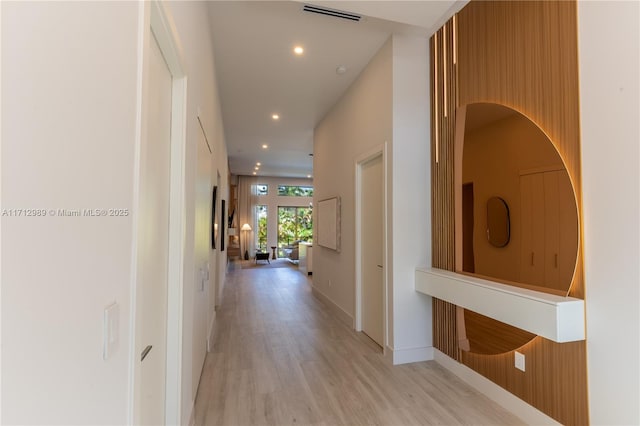 hall with recessed lighting, visible vents, light wood-style flooring, and baseboards