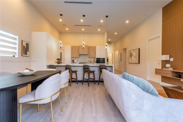 interior space with light hardwood / wood-style floors and a high ceiling