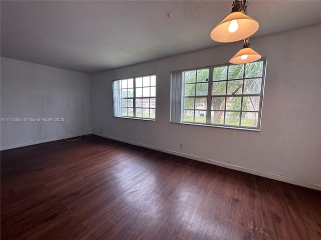 spare room with dark hardwood / wood-style floors and a textured ceiling