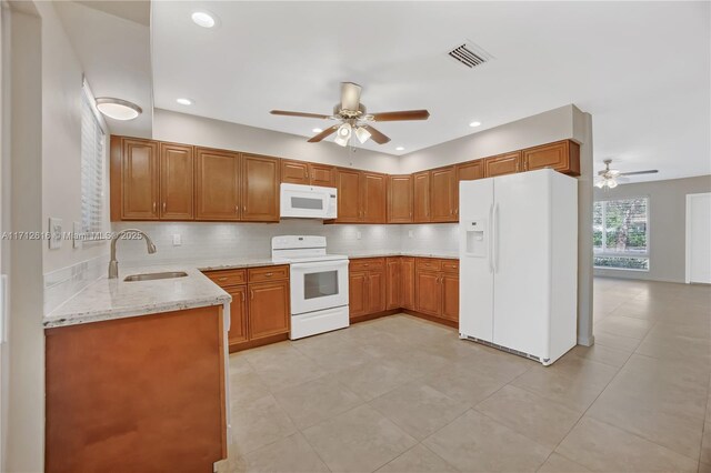 kitchen with kitchen peninsula, decorative backsplash, white appliances, ceiling fan, and sink