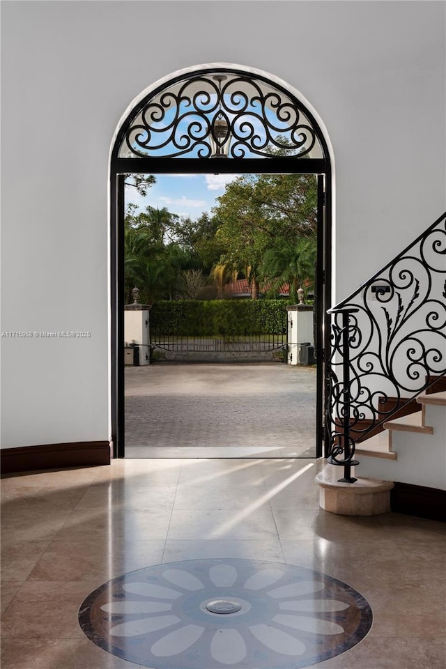 entryway featuring stairs and baseboards