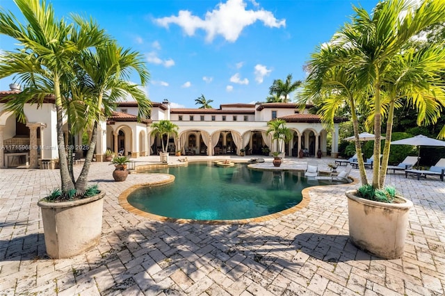 view of swimming pool with exterior kitchen and a patio