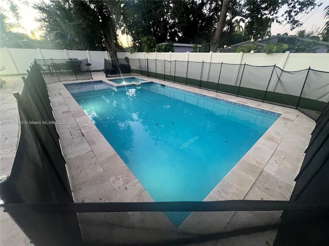 view of swimming pool featuring a patio area, a fenced backyard, a fenced in pool, and an in ground hot tub