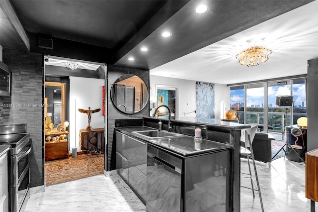 kitchen with sink, stainless steel appliances, a wall of windows, an inviting chandelier, and a breakfast bar