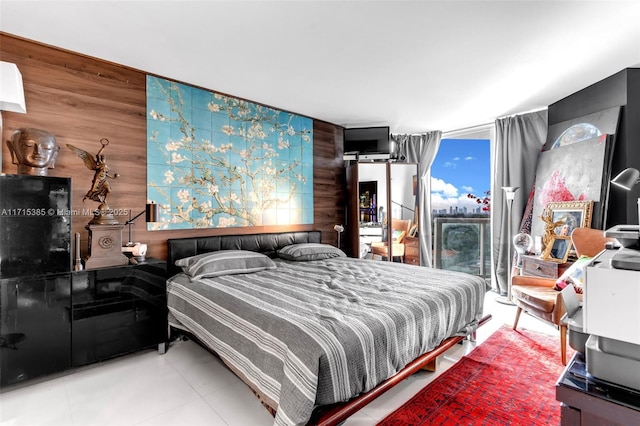 bedroom with tile patterned floors and wood walls