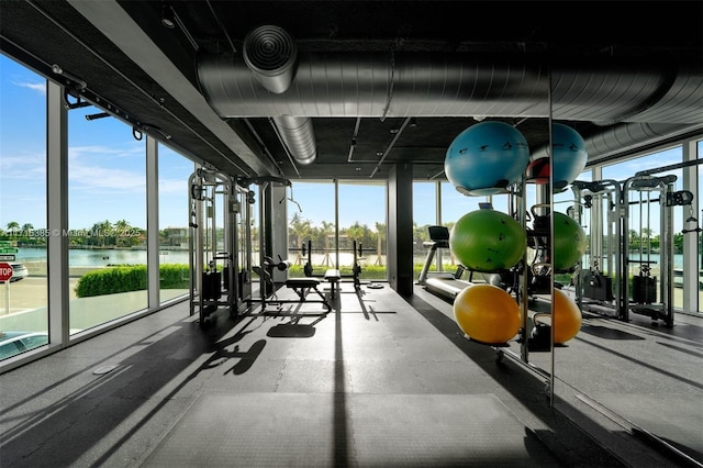 workout area featuring expansive windows and a water view