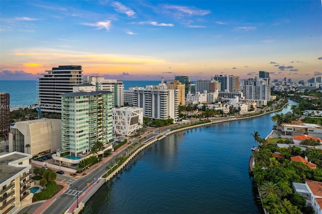 aerial view at dusk featuring a water view