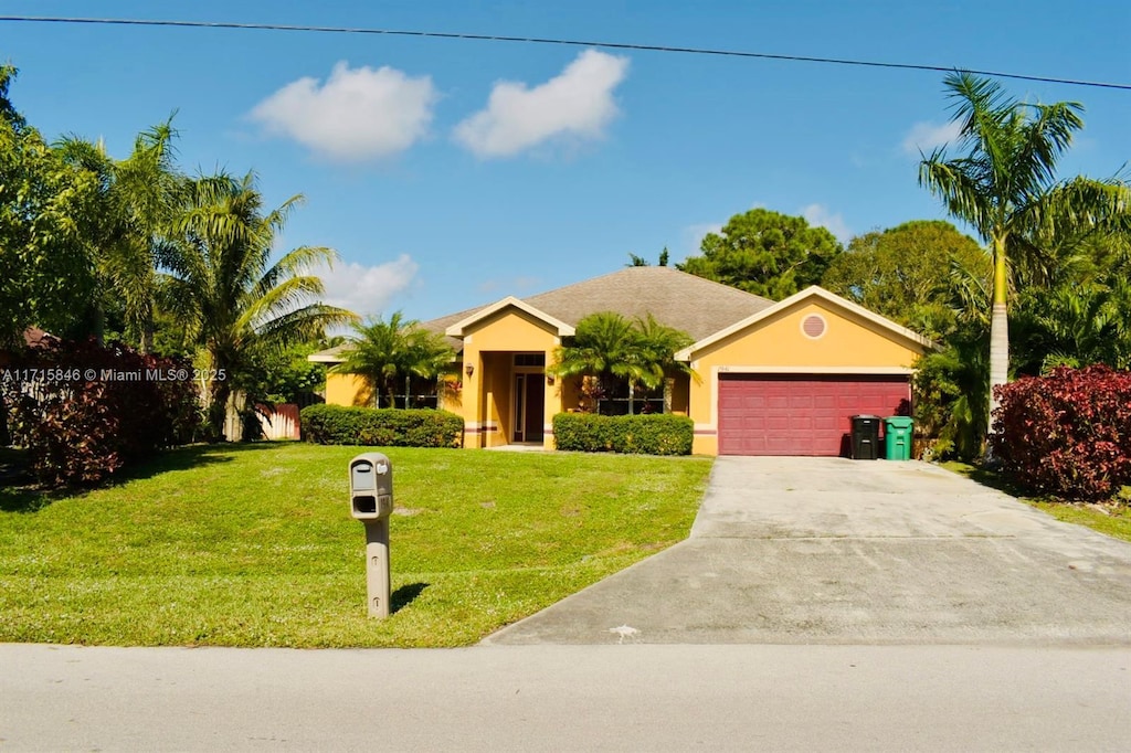 ranch-style house featuring a garage and a front lawn