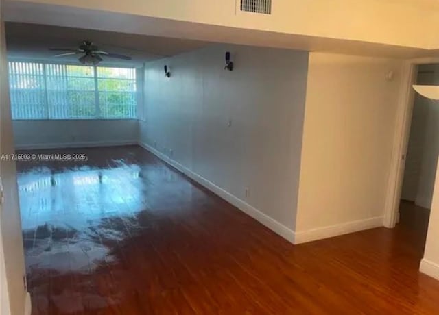 spare room with ceiling fan and dark wood-type flooring