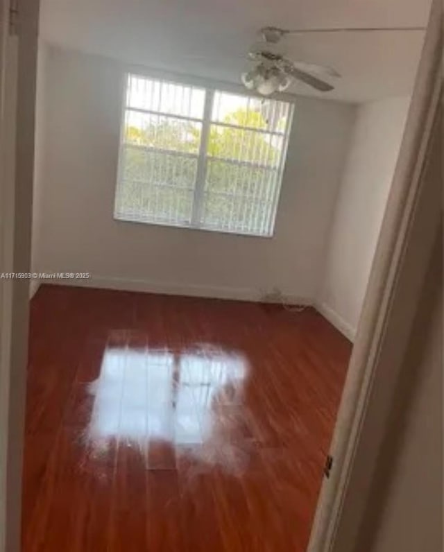 empty room with ceiling fan and hardwood / wood-style floors