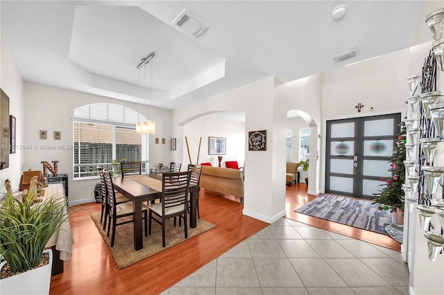 tiled dining area featuring a tray ceiling